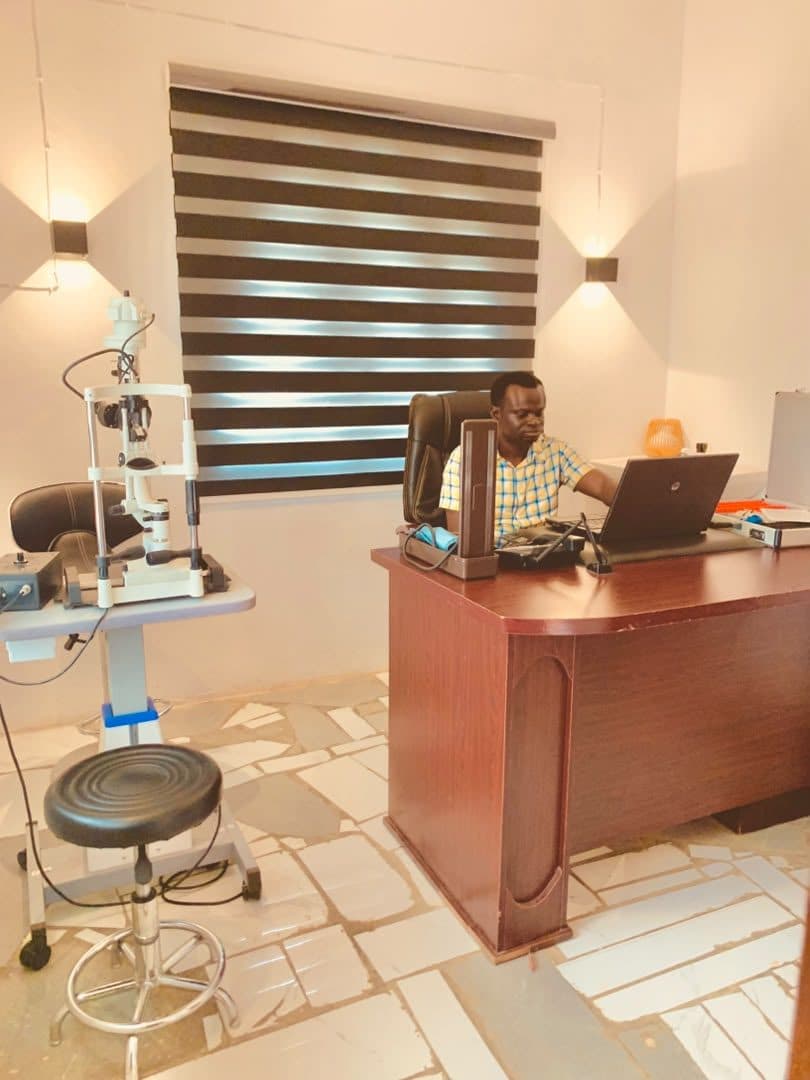 A God First specialist consulting at a slit lamp in the examination room