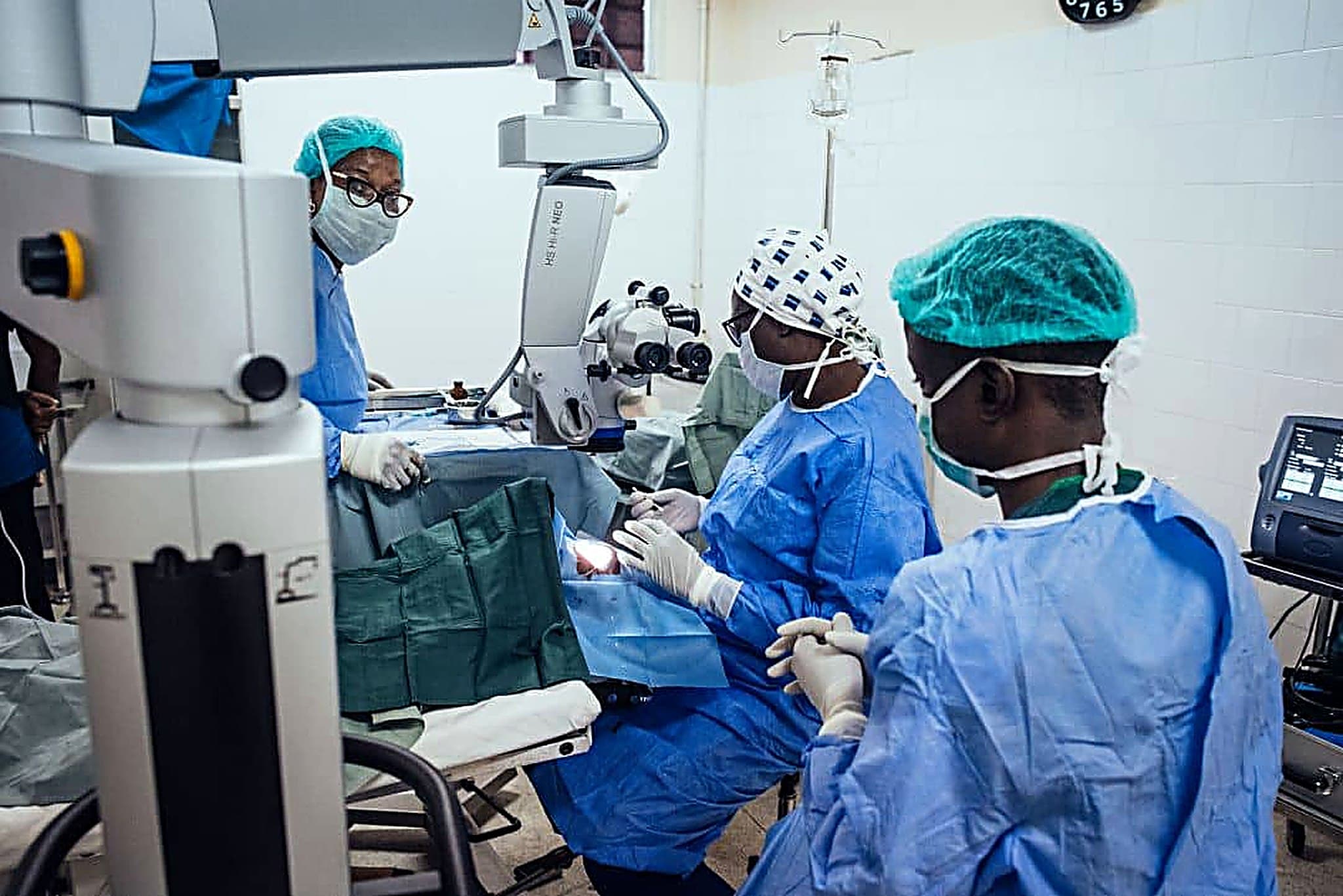 The God First surgical team operating at the Zeiss ophthalmic microscope during an eye procedure